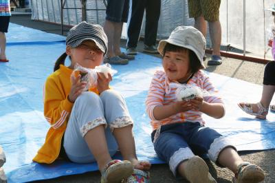 ゆめぴりかのおにぎりをほお張る園児の写真