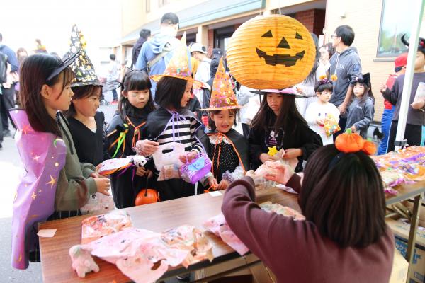 ハロウィーンフェスティバルでお菓子をもらう子どもたち